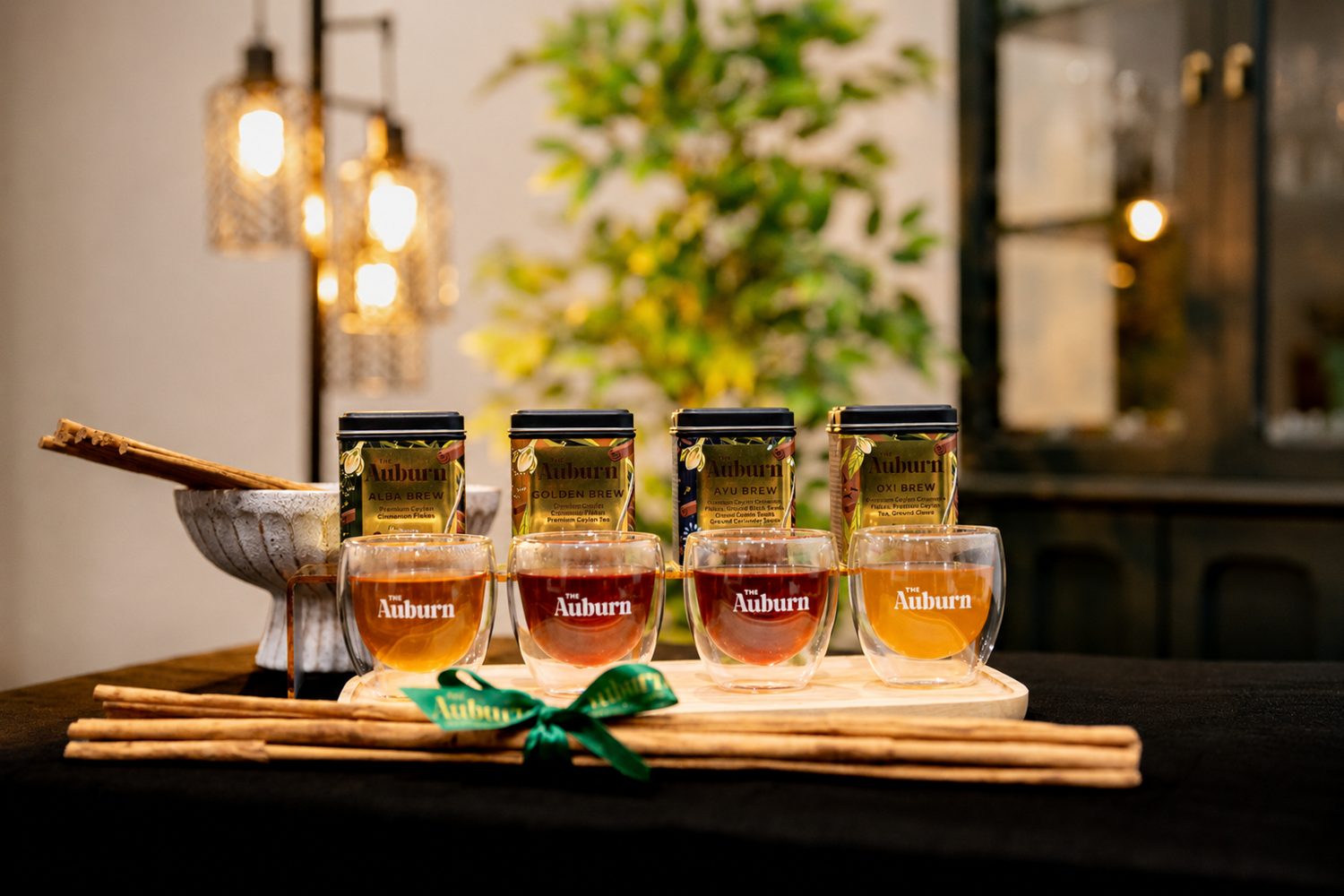 Four Auburn brews served in branded glasses on a café table with Ceylon Cinnamon quills