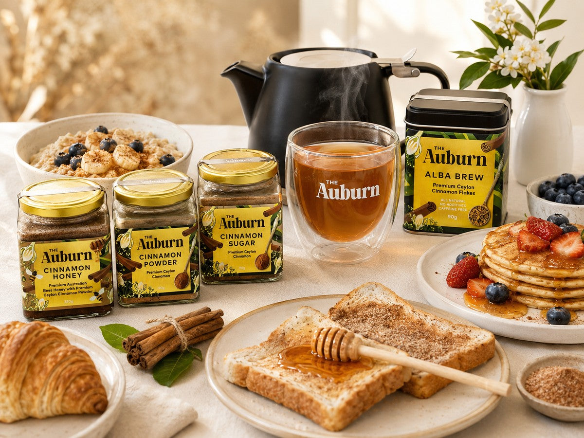 Cinnamon Honey, Cinnamon Powder and Cinnamon Sugar jars on a breakfast table with cinnamon quills, porridge, cinnamon toast and a cup of Alba Brew