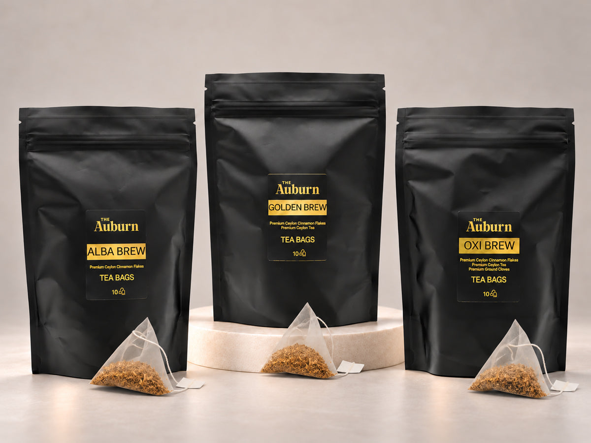 The Auburn tea bag pouches in Alba, Golden and Oxi, each with a pyramid tea bag of cinnamon in front