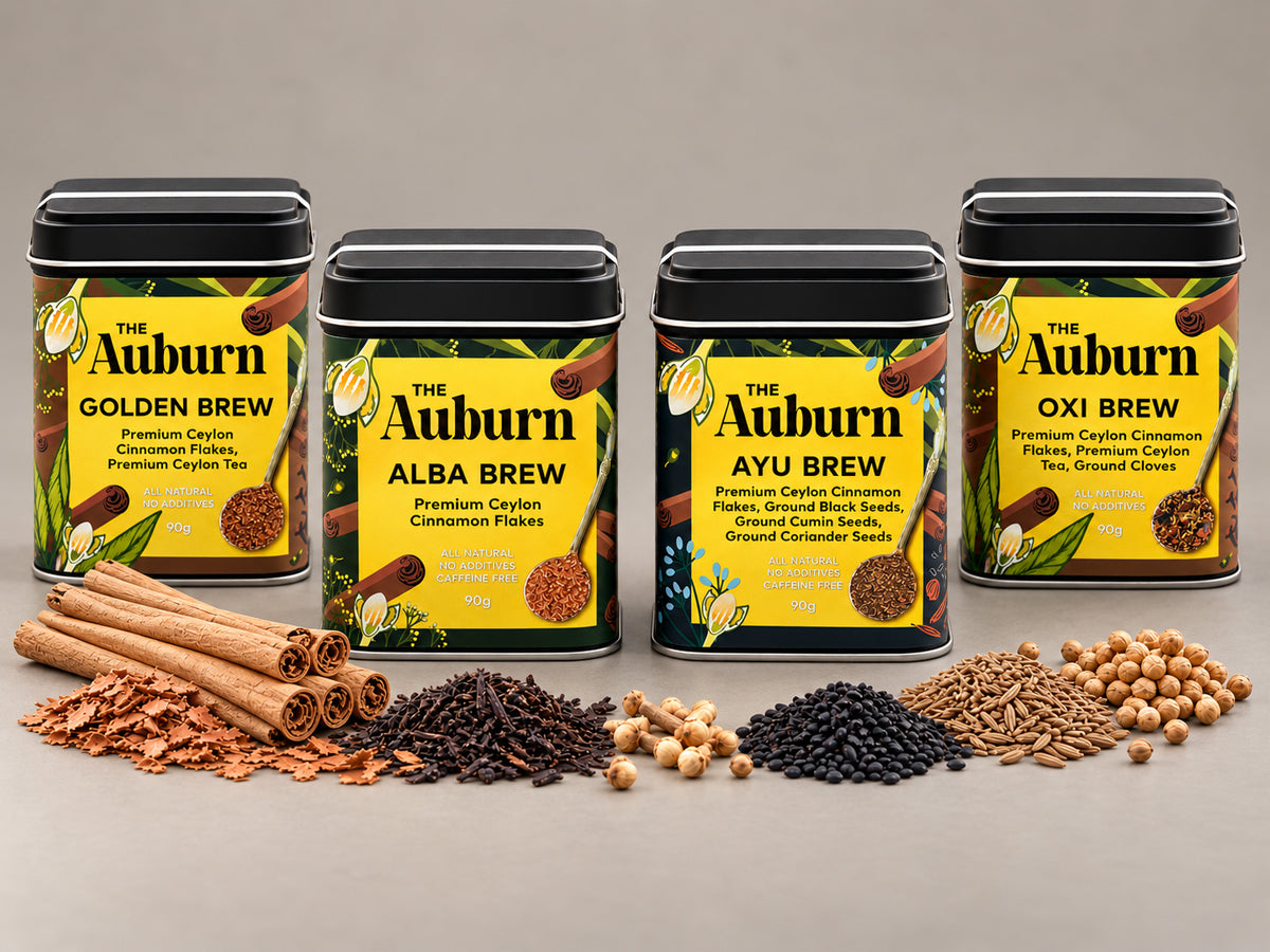 The four Auburn brew tins — Golden, Alba, Ayu and Oxi — with cinnamon quills, cloves, cumin, coriander and black seeds in front