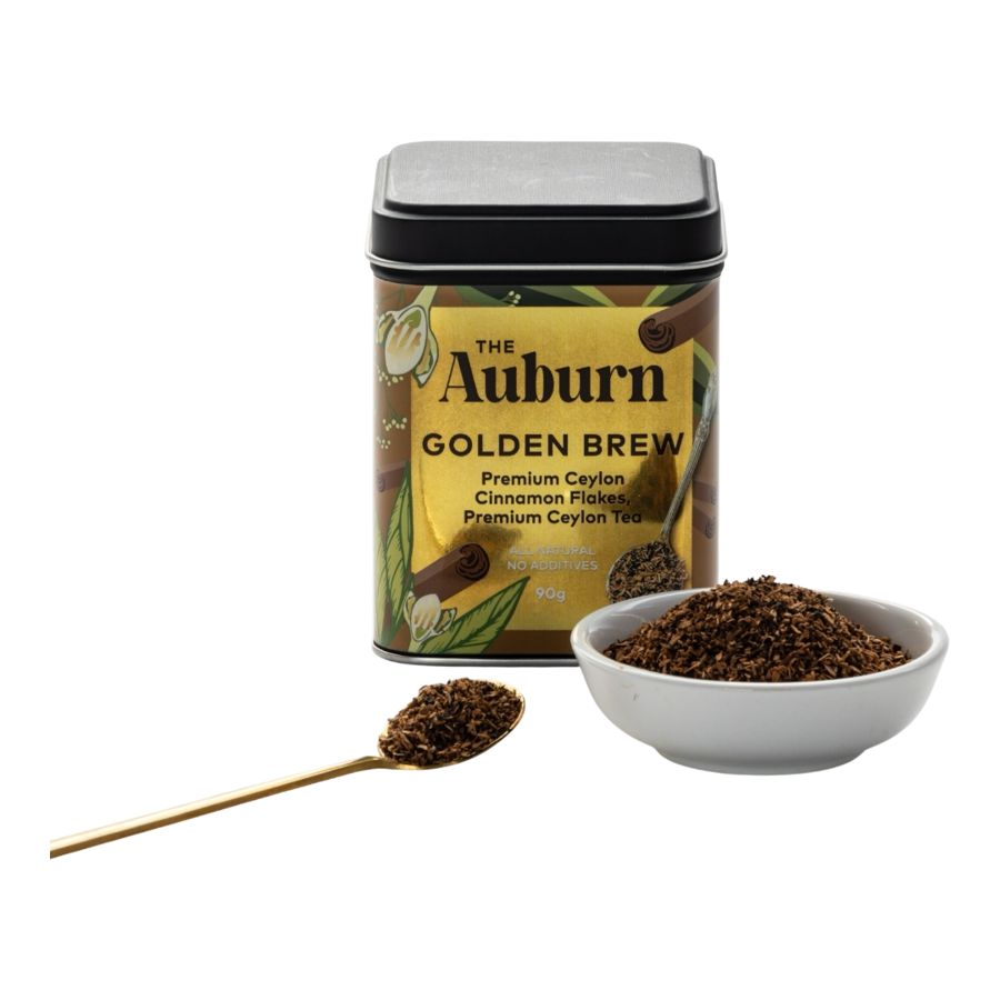 Golden Brew tin with a bowl and gold spoon of cinnamon flakes and Ceylon tea