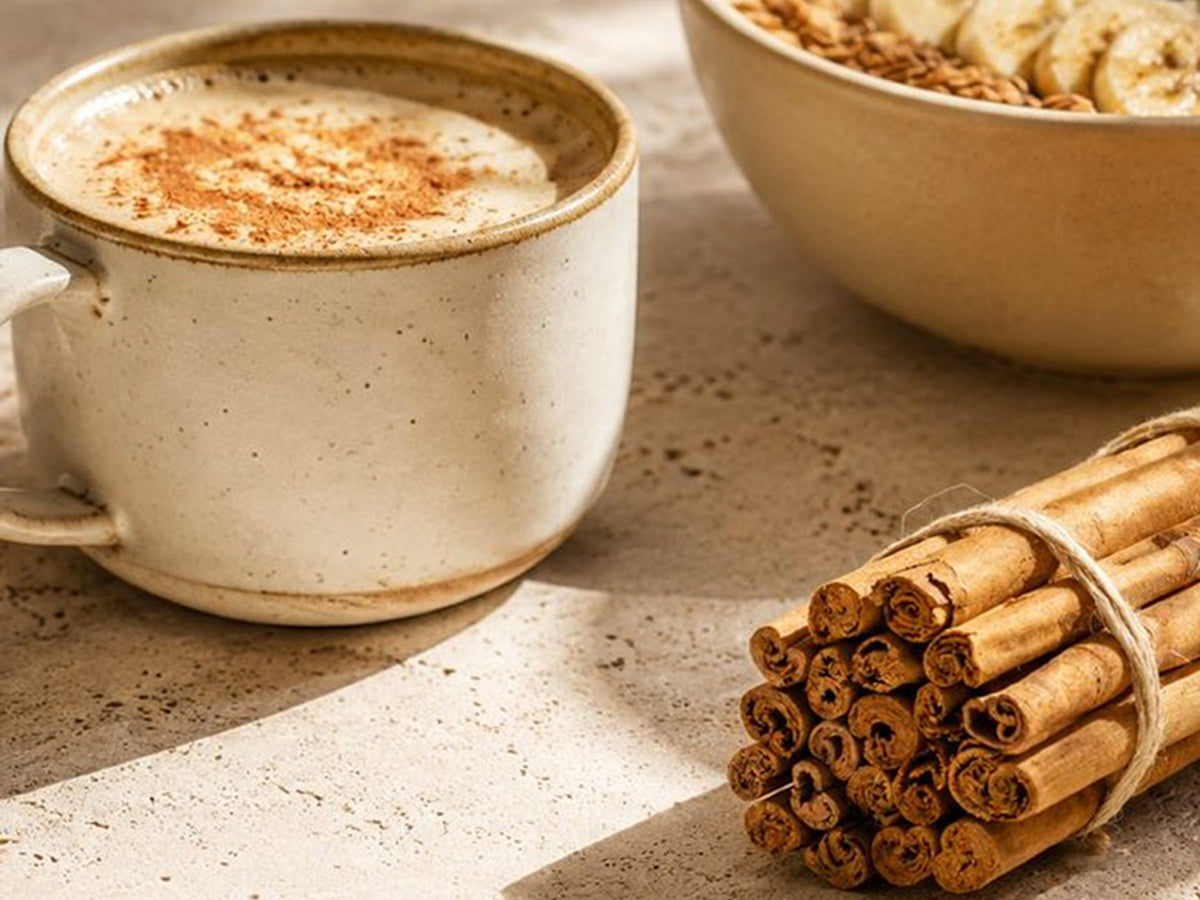 A Cinnamon Honey Latte in a ceramic cup, dusted with Cinnamon Powder.