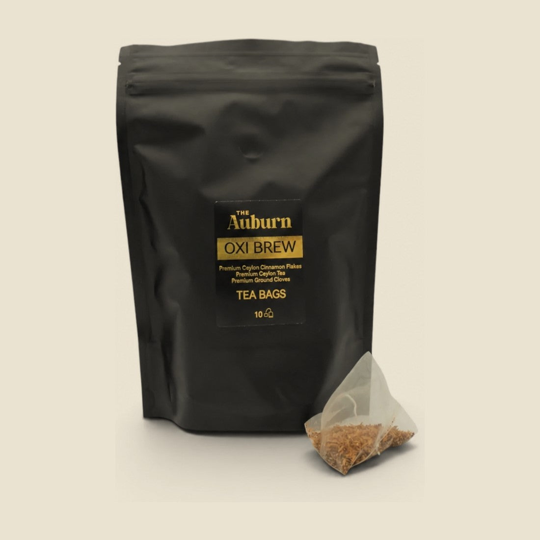 Oxi Brew tea bag pouch with a pyramid bag of cinnamon, tea and white cloves in front